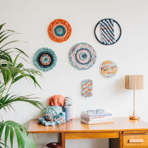 Cassandra Sabo’s ‘West Coast 2’ woven circular textile wall-hanging from her West Coast Collection hung on the wall above a desk