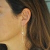 Silhouette silver pearl earrings on model