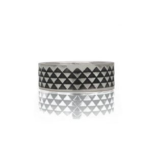 Silver ring with oxidised triangle pattern lying flat on a white background