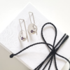 Handmade Silver CZ Circle Drop Earrings are placed on the white gift box tied with black cotton string.