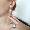 Statement geometric earrings and ring worn on a white model