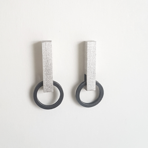 Hand-carved Minimalist Silver Patina Stud Earrings is shown on the white holder.
