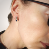 Silver sterling silver geometric stud earrings are worn on a white woman.