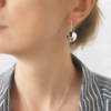 Silver Cubic Zirconia Circle Drop Earrings worn on the woman in a striped shirt.