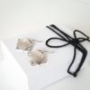 Geometric silver drop earrings on the white gift box tied with black cotton string