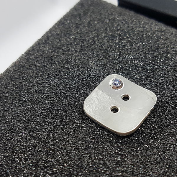 Handmade Tailored Geometric Silver CZ stone Apparel Button is placed on the black foam block.