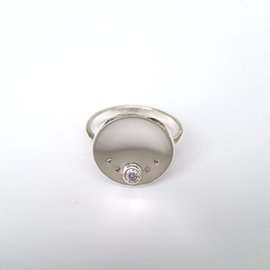 Minimalist Silver CZ Circle Ring is placed on the white surface.