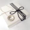 Sterling silver Statement pendant is placed on the white gift box tied with black cotton string.