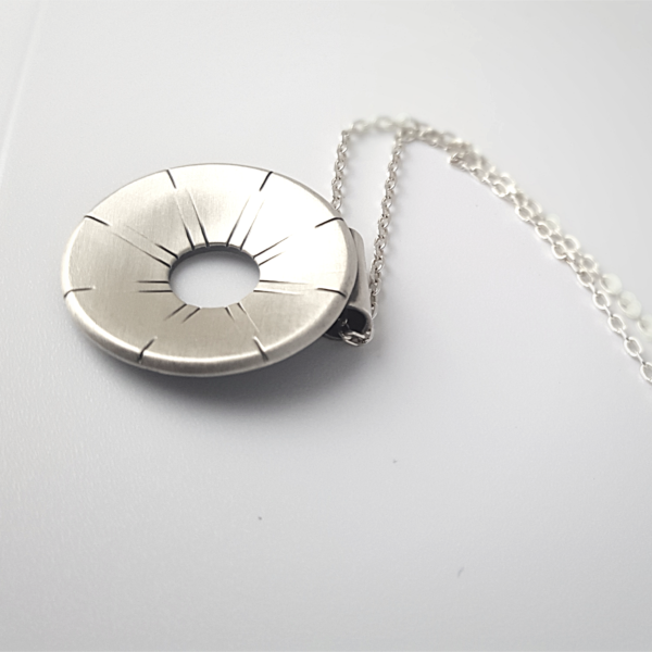 Artisan oxidised sterling Silver pendant necklace is shown on a white surface.