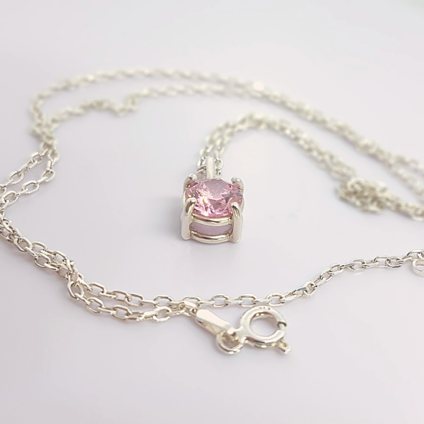 Handmade Custom 7mm Cubic Zirconia Solitaire Pendant Necklace is placed on the white surface.