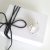 Geometric bold ring made from 925 silver is placed on the white paper gift box tied with black cotton string
