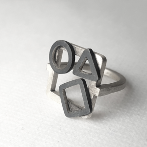 Artisan Geometric Patina Statement Ring in Sterling Silver is displayed on the white surface.