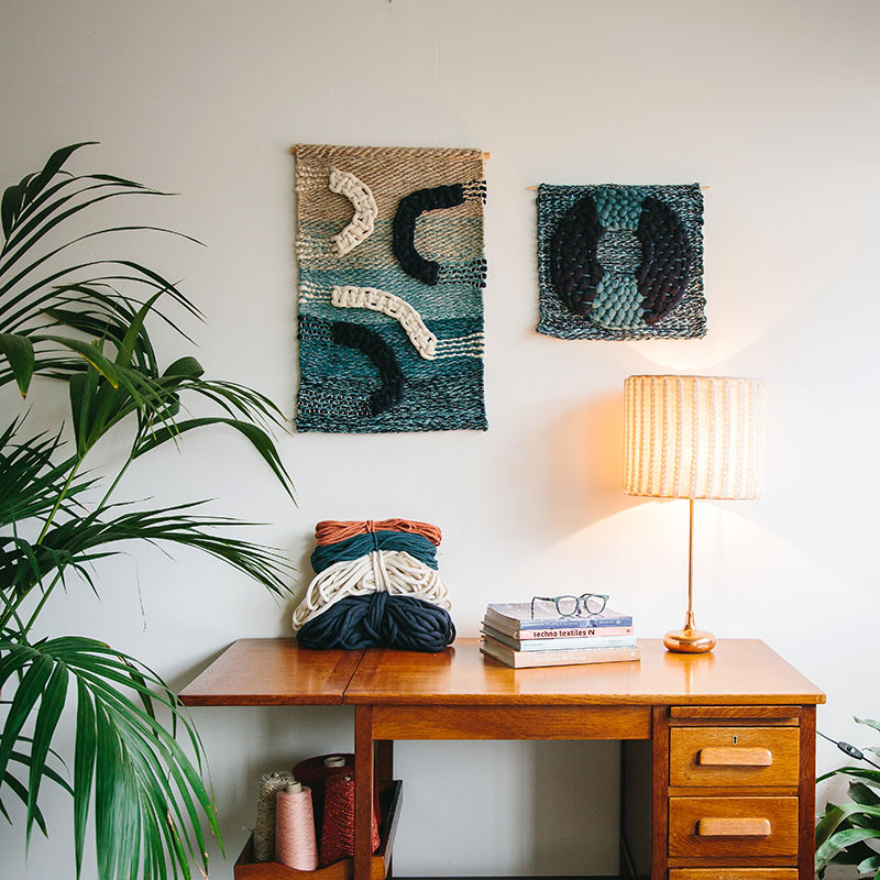 Cassandra Sabo’s ‘Flow’ handwoven textile wall-hanging from her West Coast Collection hung on the wall beside the ‘Salmon’ wall-hanging.