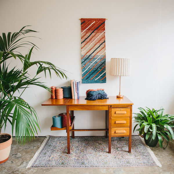 Cassandra Sabo’s ‘Shoreline’ handwoven textile wall-hanging from her West Coast Collection hung on the wall above a desk