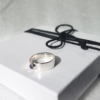 Handmade Sterling silver ring with one gemstone is placed on the white gift box tied with black cotton string.