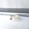 Sterling silver ring with overlapping is placed near the smartphone.