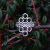 Silver Beaded Quatrefoil Ring - view from the front - against foliage background