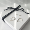 Handmade Sterling silver earrings are placed on the white gift box tied with black cotton string.