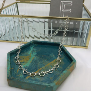 Arc Faceted Art deco inspired necklace displayed on marbled jewellery tray with glass jewellery box and Faceted gift box