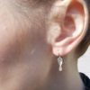Handmade Silver Drop Dangle Earrings on an earlobe.