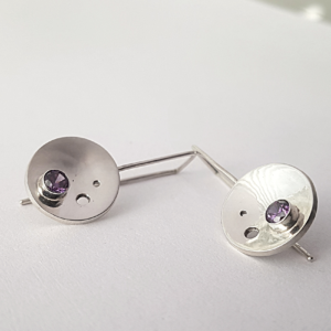 Handmade Drop Earrings in sterling silver with cubic zirconia are on a white surface.