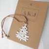 Handcrafted Silver Christmas Tree - Shaped Hanging Keepsake on a brown Andy Kashtan Jewellery paper tag.
