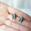 Contemporary sterling silver studs with partial patina on the palm.
