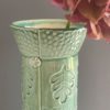 Detail green cylinder vase with leaf pattern
