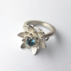 Contemporary Designer Silver Ring with Blue Topaz on on a white surface.