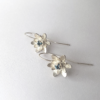 Artisan silver drop earrings with blue topaz on a white surface.