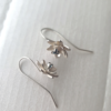 Unique handmade silver earrings with topaz on a white surface.