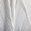 Detail of ribbed surface of white glass sculpture.